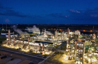 A stunning night aerial shot of a well-lit oil refinery in Rosemount, Minnesota, showcasing its industrial beauty.