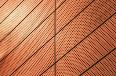 Abstract view of a modern metal wall with geometric patterns and warm lighting.