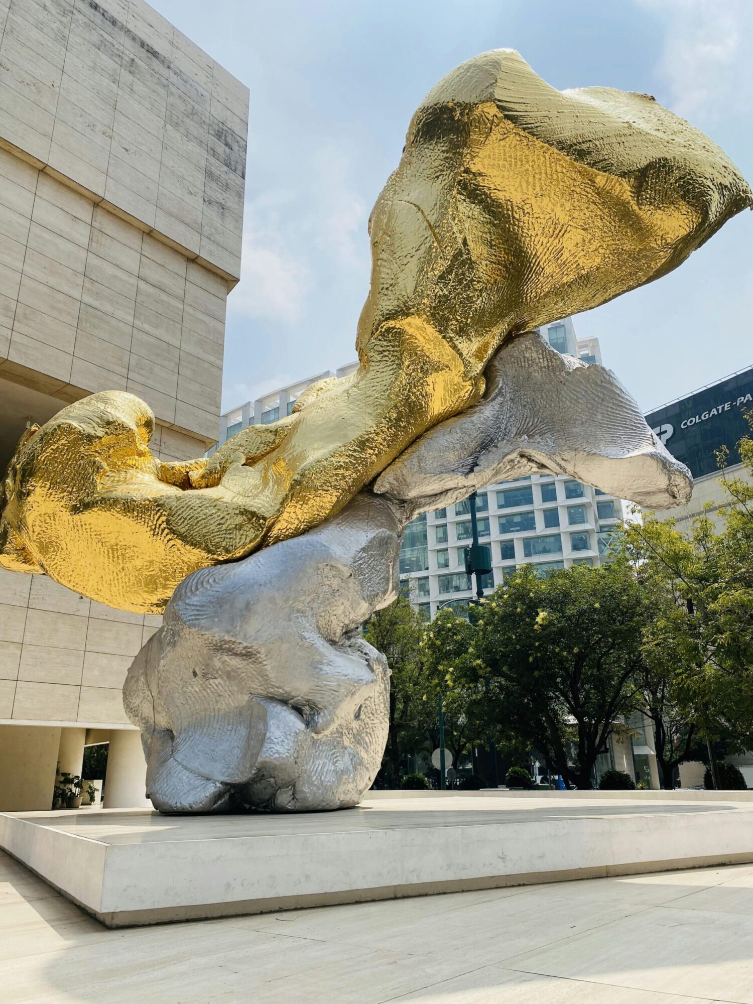 pexels-photo-15161706-15161706 A striking gold and silver sculpture in urban Mexico City under a bright sky.