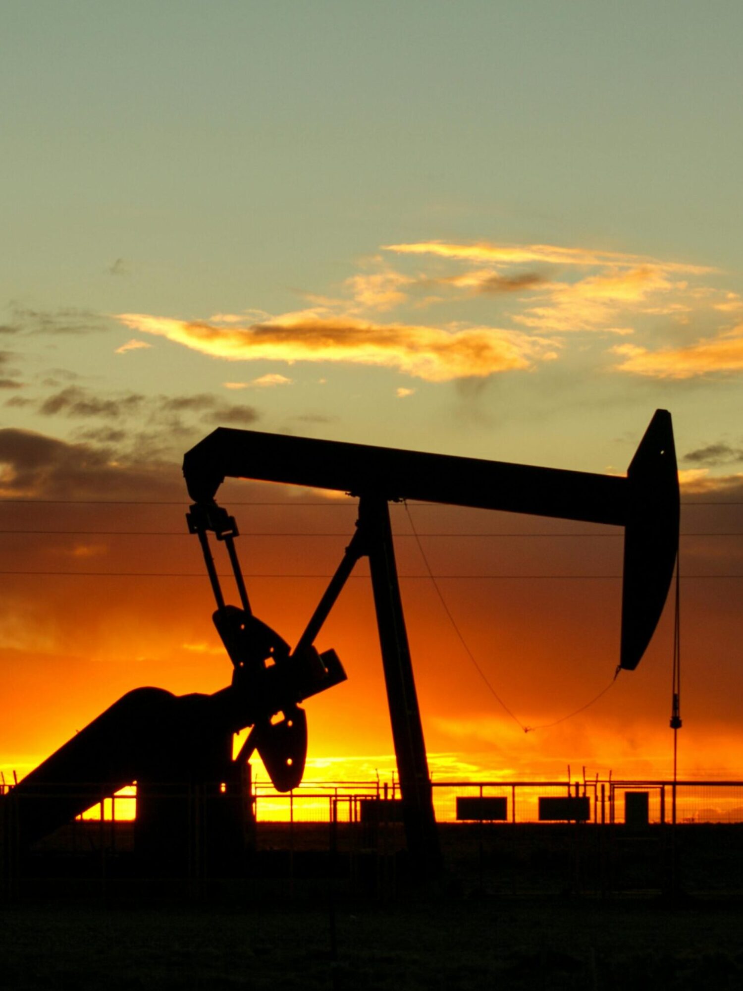 pexels-photo-16862261-16862261 Dramatic silhouette of an oil pump jack against a vibrant sunset sky, emphasizing energy extraction.